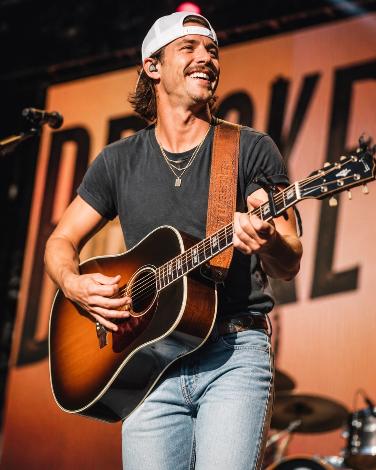 A celebratory photo of a country-rock artist performing on stage, representing Shaboozey's success