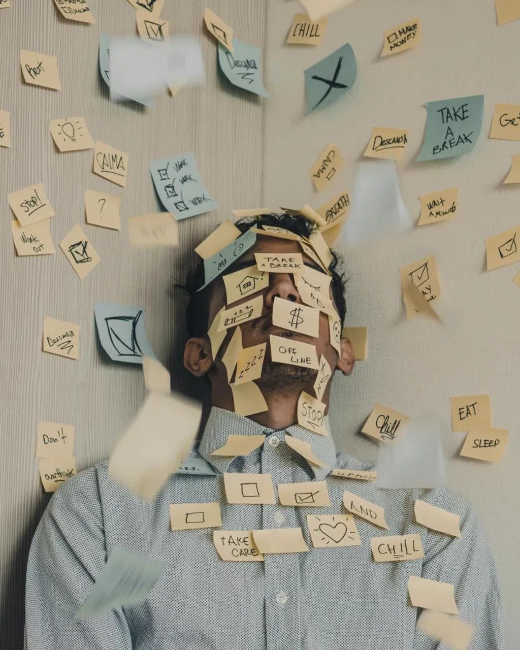 A person overwhelmed by sticky notes, representing the mental load and stress that often spills over into our relationships.