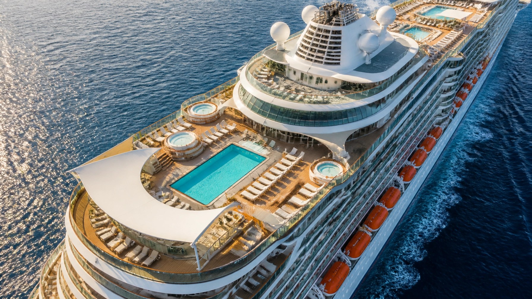 Aerial view of a large modern cruise ship pool deck and upper decks at sea with no people visible