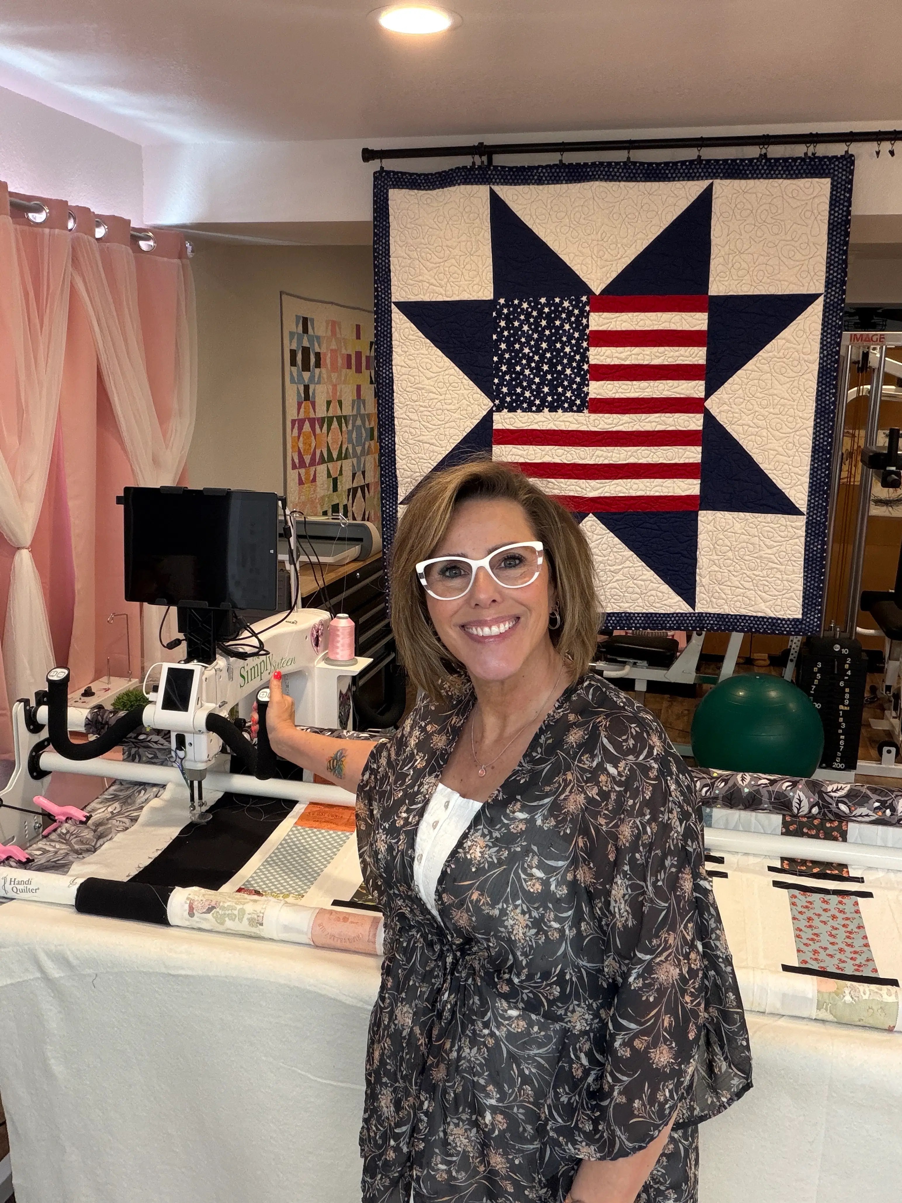 Anisa in her studio, smiling and surrounded by her creative tools, showing a warm and welcoming atmosphere.