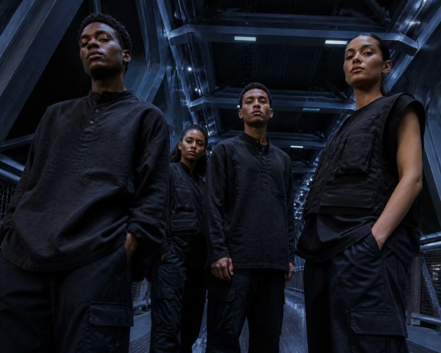 People of color wearing 90s-inspired minimal chic tactical fashion in an industrial space station setting.
