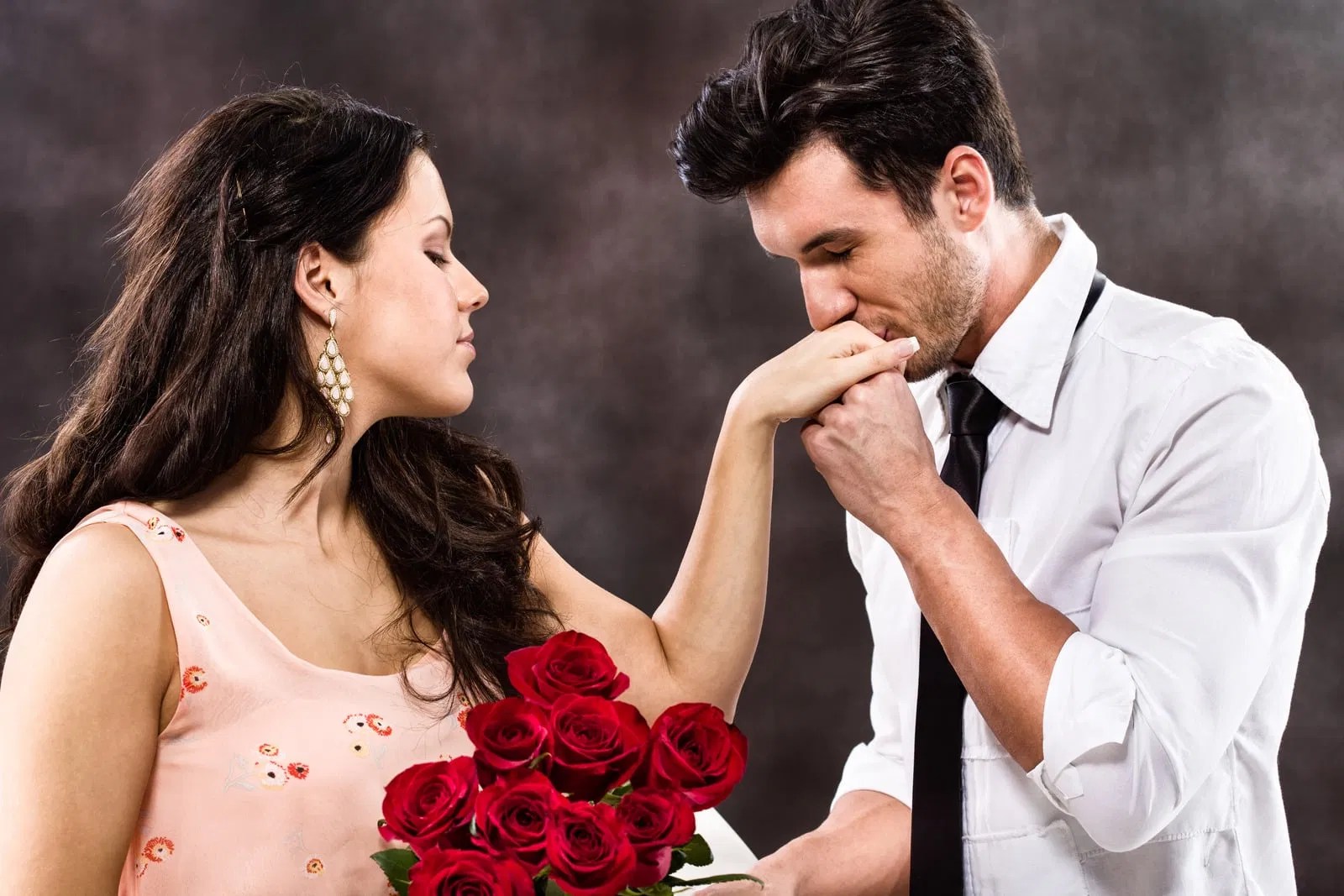 A romantic moment where a man gently kisses a woman's hand, symbolizing the beautiful exchange of masculine devotion and feminine receiving.