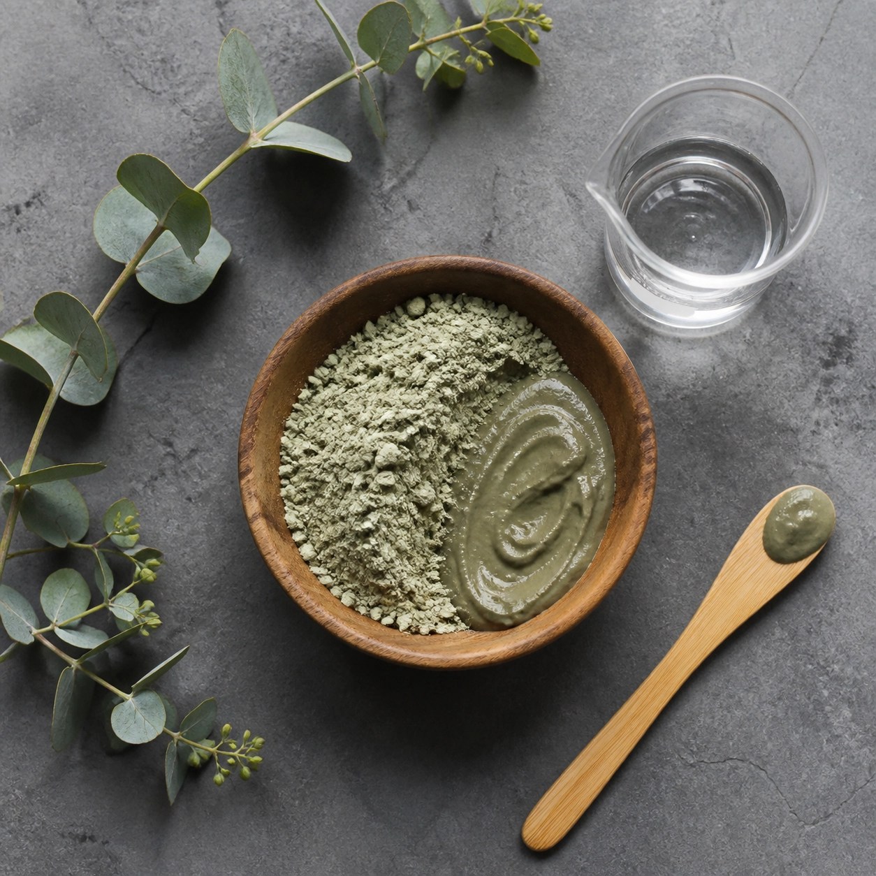 Natural green clay powder and bamboo spatula prepared for a detox muscle poultice application.