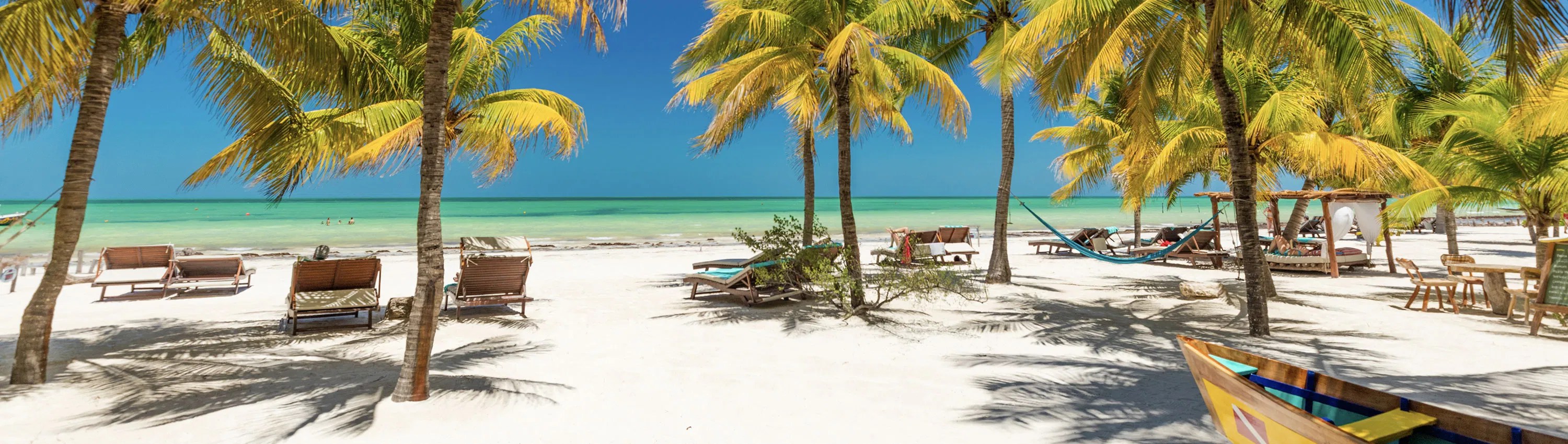 White sandy beach with palm trees in Mexico