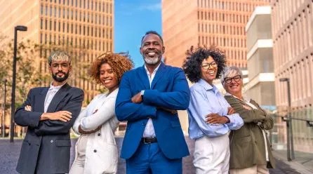 Group of five empowered Black professionals standing in a city business district