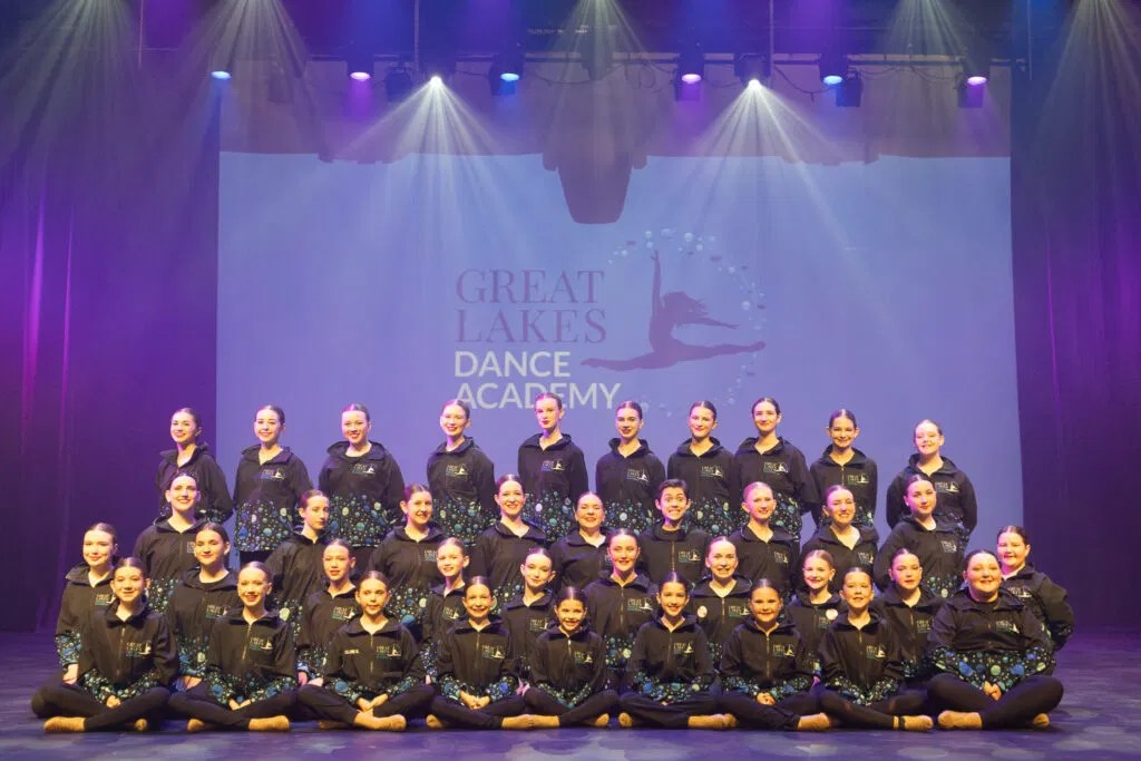 The full Great Lakes Dance Academy Company team standing and sitting on stage
