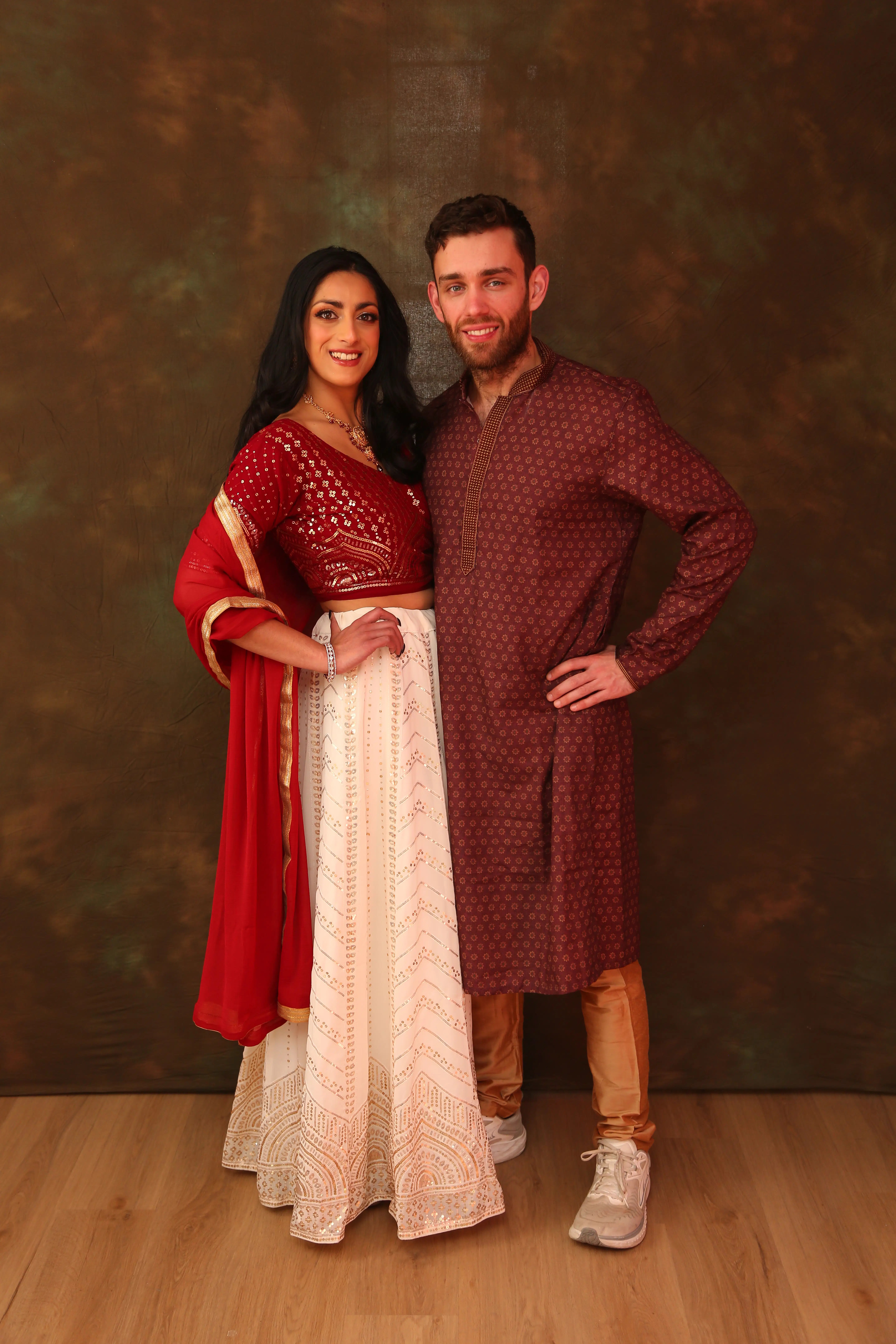 Akuti and Rob in coordinated traditional attire during their formal studio portrait session.