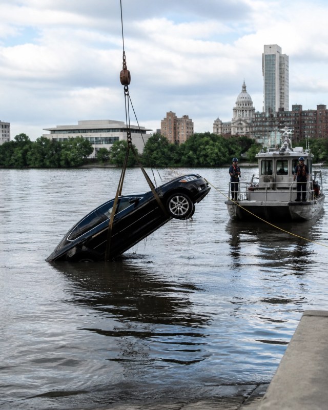 A recovery operation involving a civilian vehicle near the Hudson River shoreline