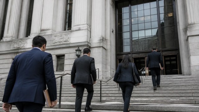 New York courthouse exterior with attorneys carrying document folders