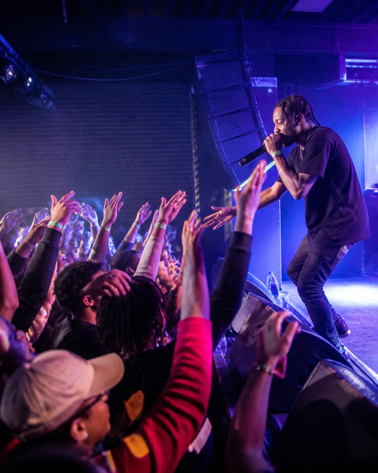 Authentic event photography of an energetic underground hip-hop concert at a venue in Philadelphia, showcasing the power of the indie scene