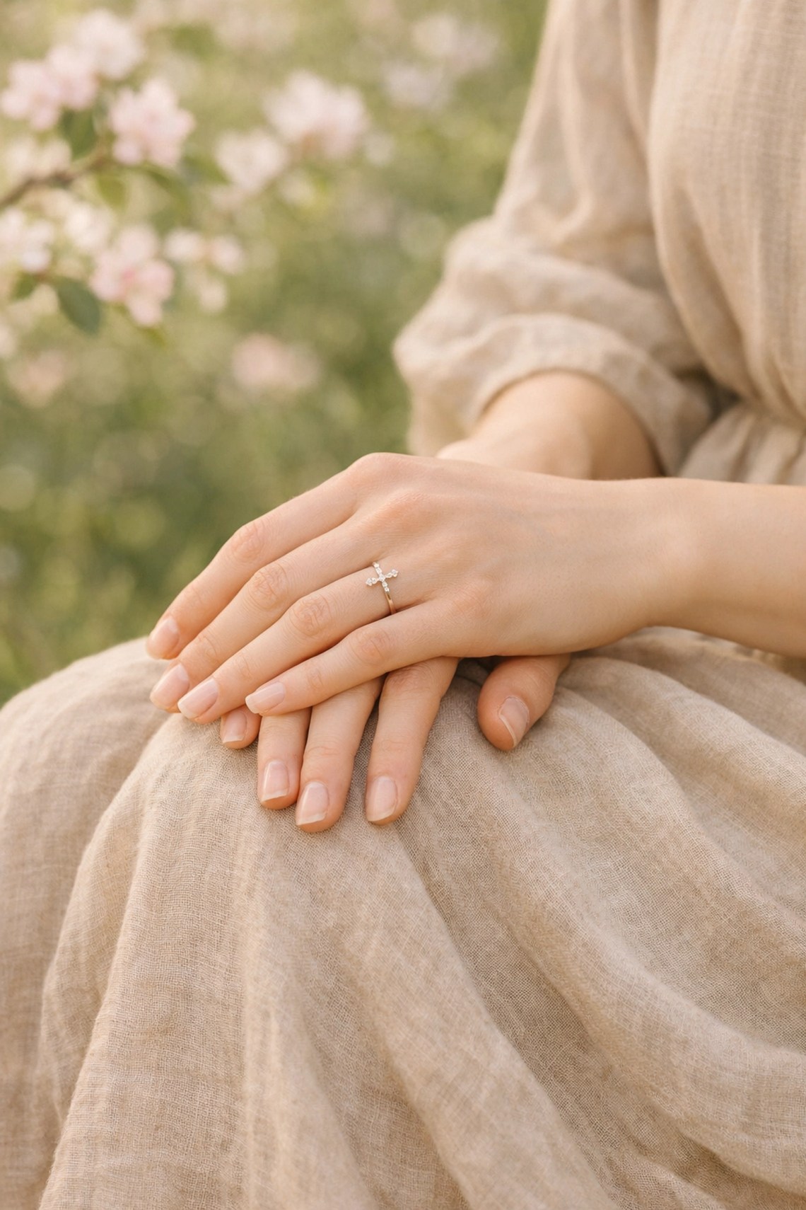 Close-up of a woman’s hands with a cross ring in a garden, representing a rooted faith lifestyle.