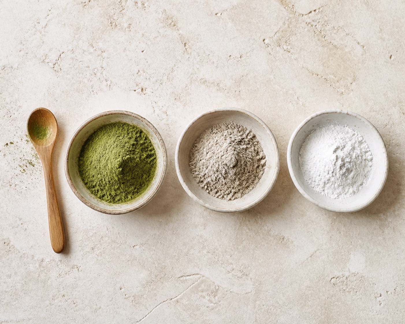 Comparing French green clay, bentonite, and kaolin clay powders in bowls for skin and detox use.