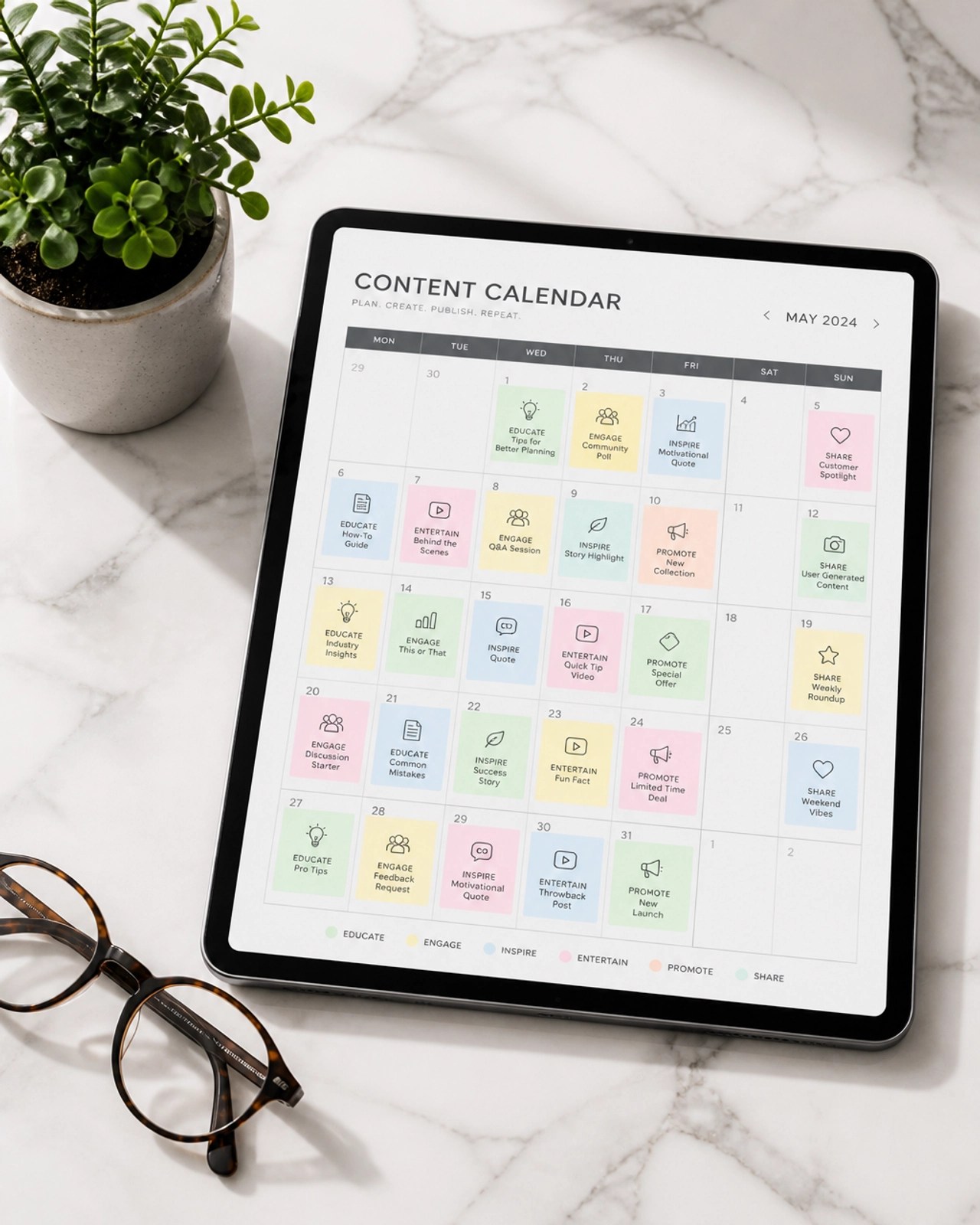 A tablet showing a structured content calendar alongside professional tools and a plant