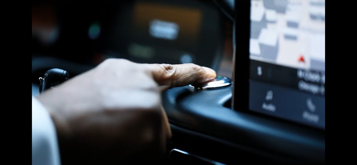 Professional chauffeur preparing a luxury vehicle with navigation display