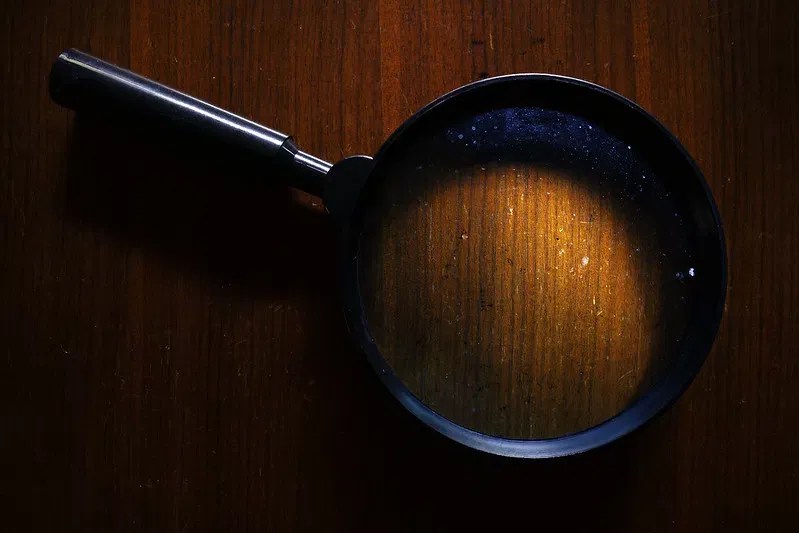 A magnifying glass over documents symbolizing rigorous audit readiness
