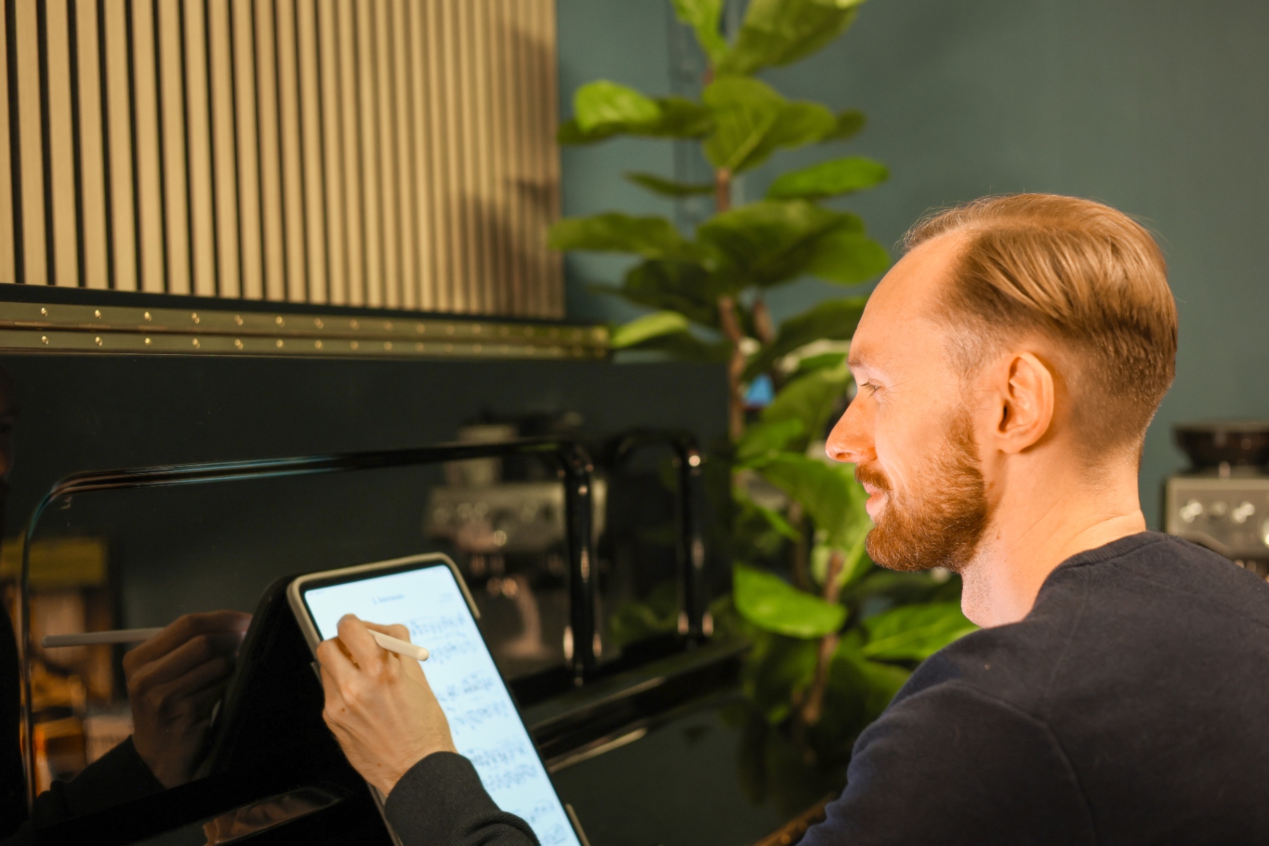 A piano teacher using a tablet with digital sheet music in a modern studio
