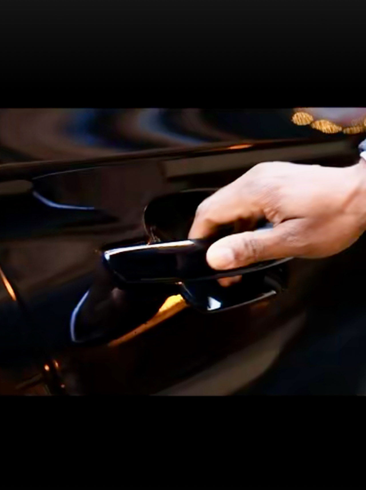 A Fiona’s Carriage chauffeur opening the door of a polished luxury vehicle