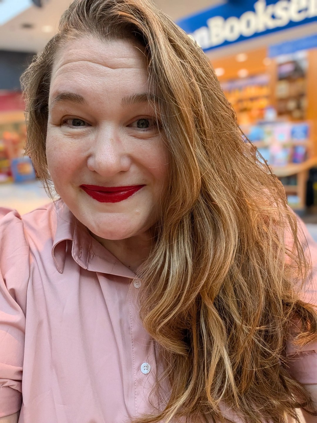 Meg Watt smiling warmly in a bookstore setting, reflecting on continuous learning and leadership habits