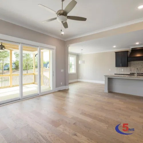 A bright, open-plan refurbishment with light oak flooring and large glass doors, reflecting a high-quality residential transformation.