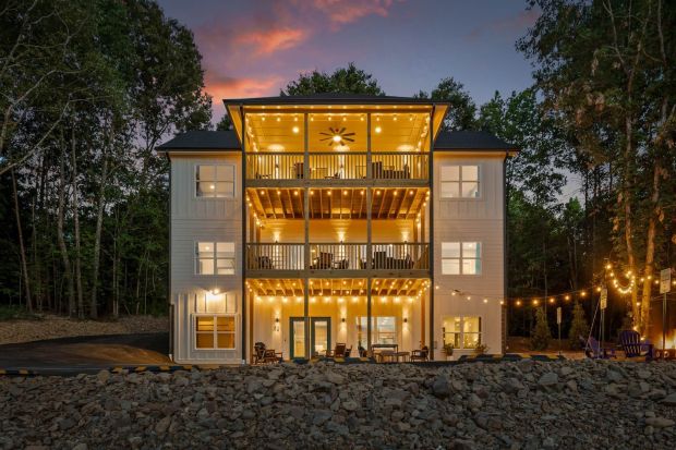 Warmly lit mountain retreat estate at dusk surrounded by trees