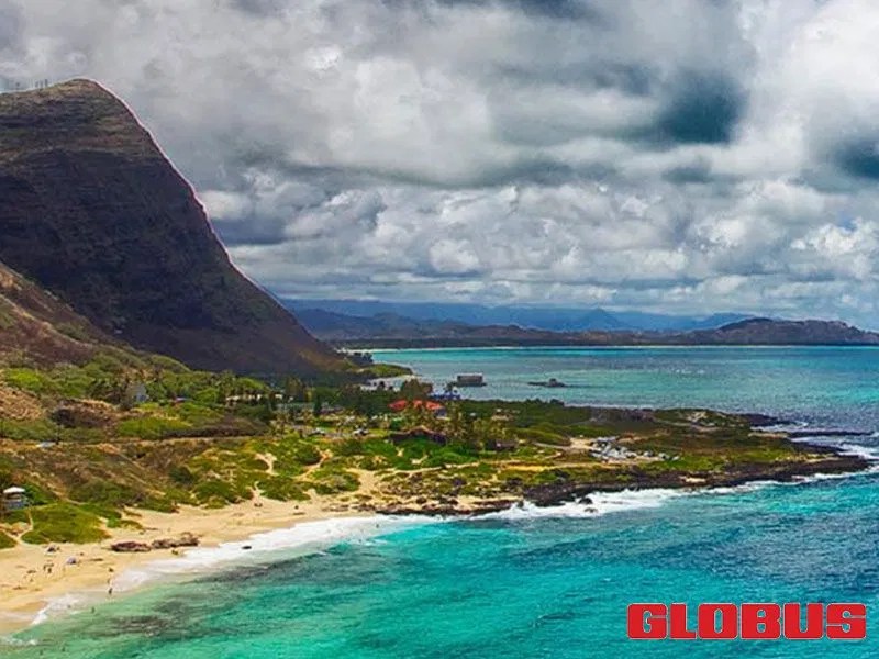 Scenic view of a lush Hawaiian coastline, featuring turquoise waters, sandy beaches, and dramatic mountains