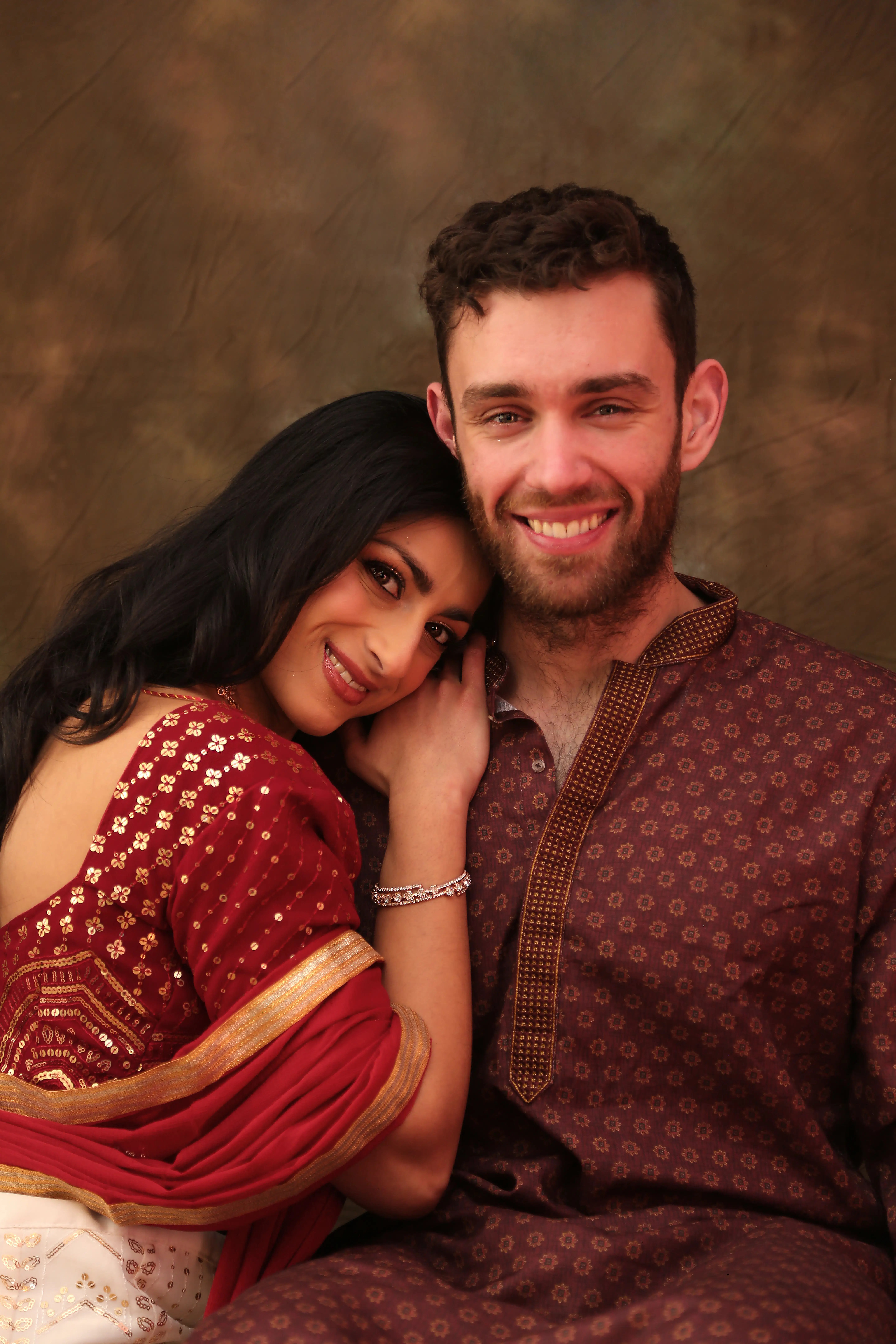 Akuti and Rob smiling in formal traditional portraits, showing their versatility beyond fitness.