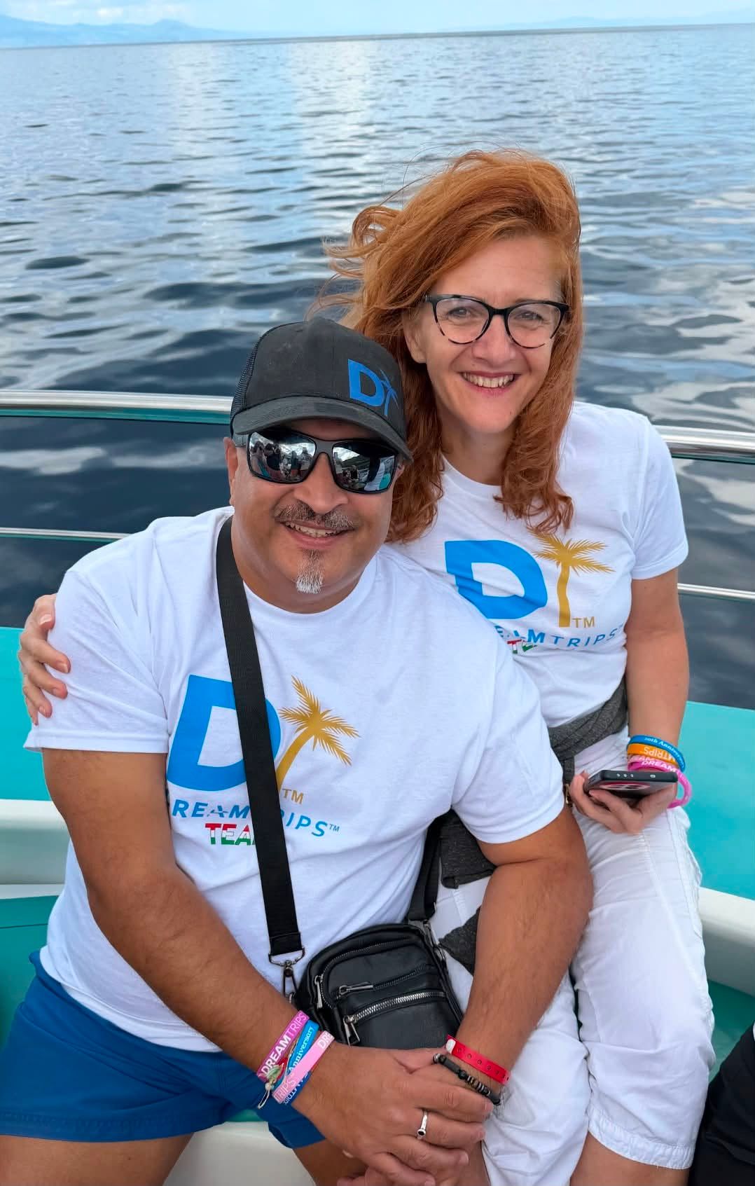 A couple in DreamTrips shirts enjoying a boat outing together