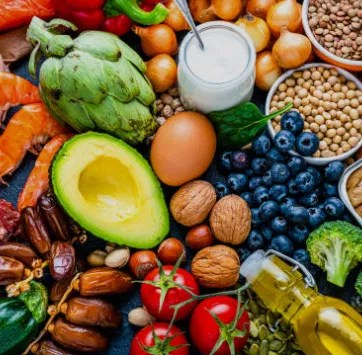 A colorful array of nutrient-rich foods including salmon, eggs, nuts, and leafy greens, perfect for supporting muscle mass and metabolic health.