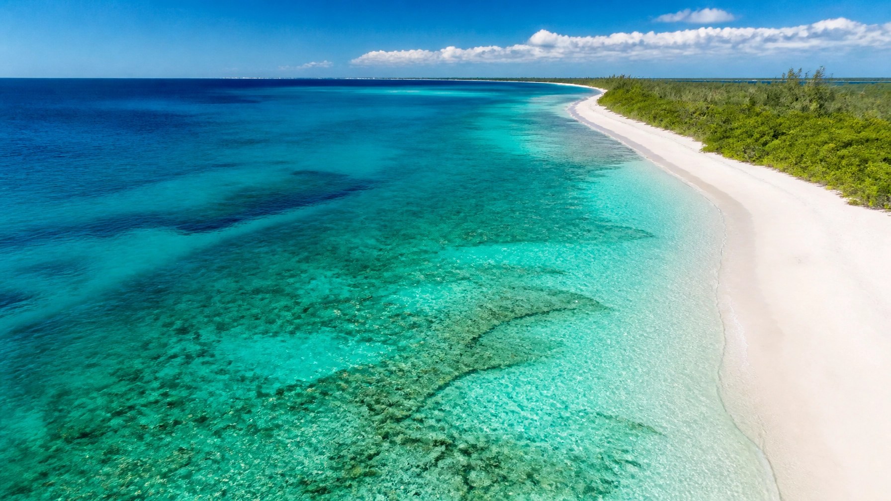 Aerial view of transparent turquoise water along Grand Cayman’s pristine coastline