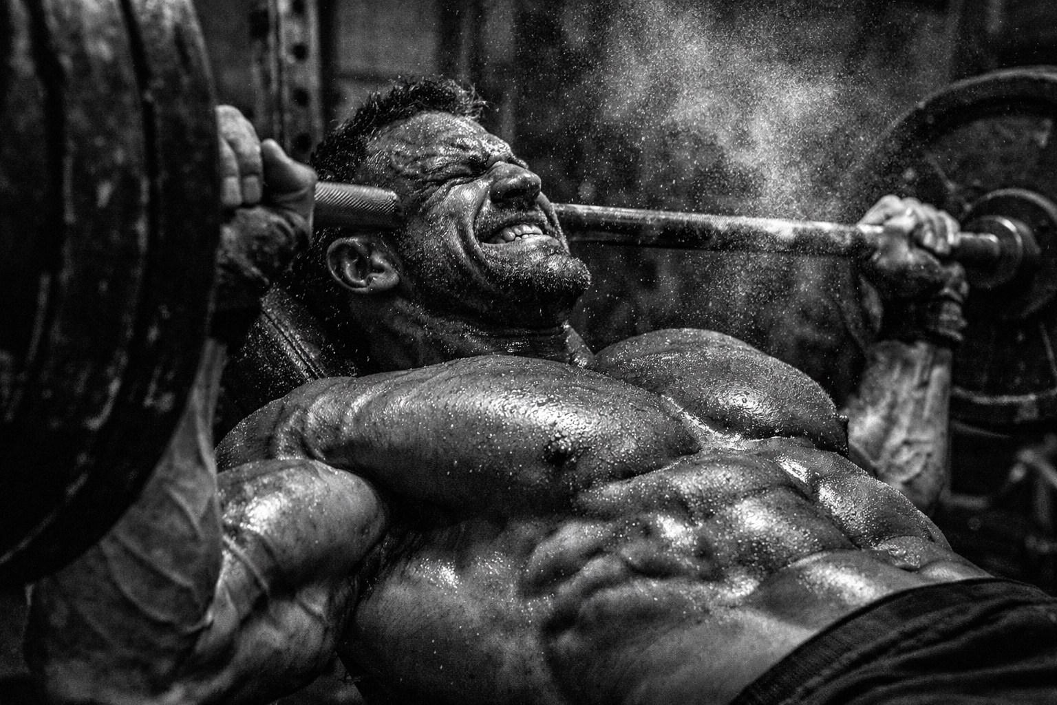 Intense close-up of an athlete’s striated pectoral muscles during a heavy bench press for chest hypertrophy.