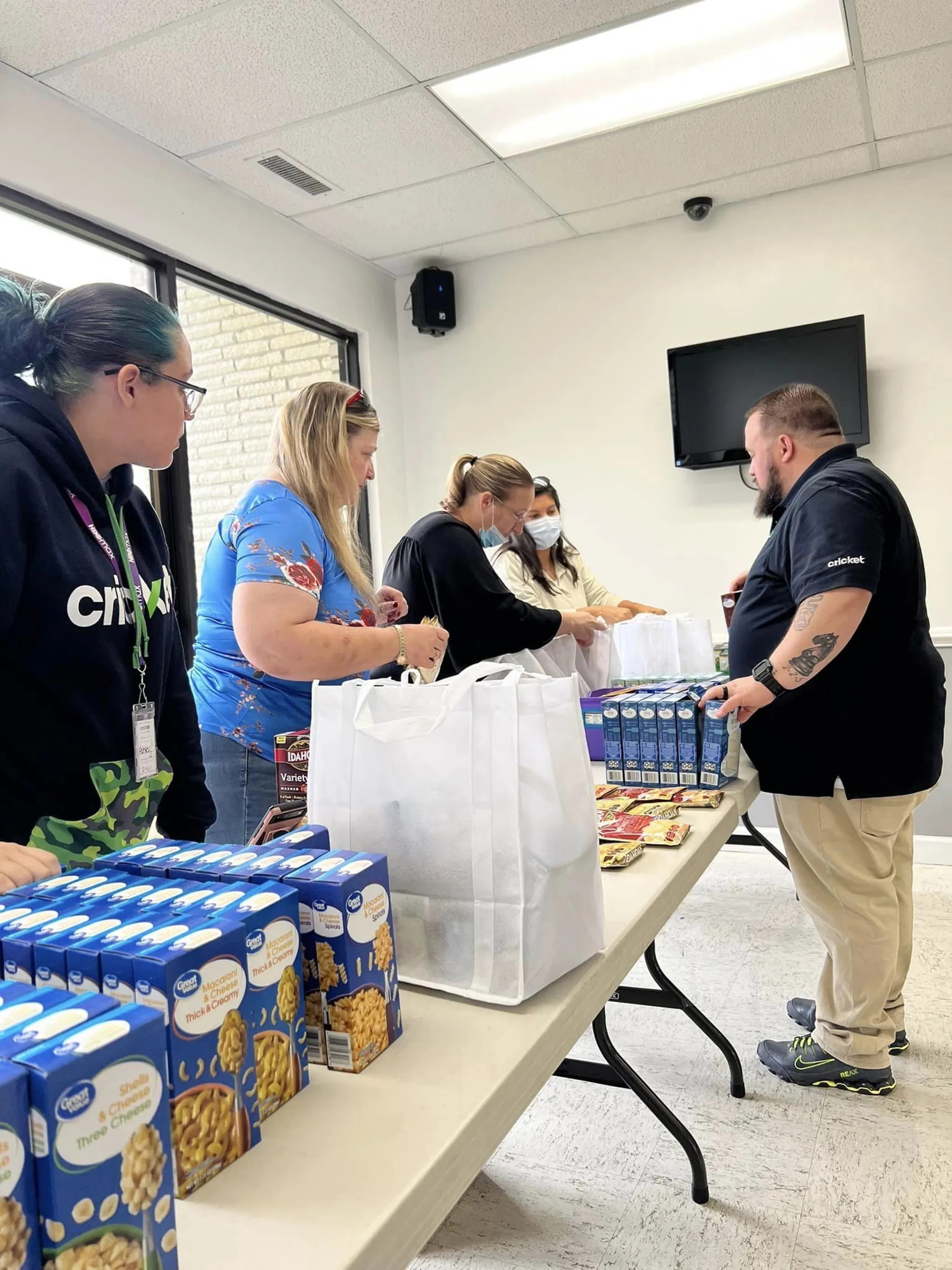 Volunteers from New Vision Ministries packing food items for a community outreach event, showcasing teamwork and service.