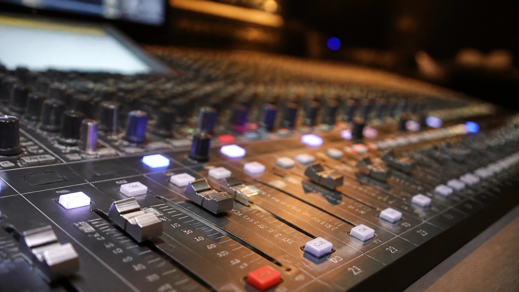Professional studio mixing console soundboard with glowing faders