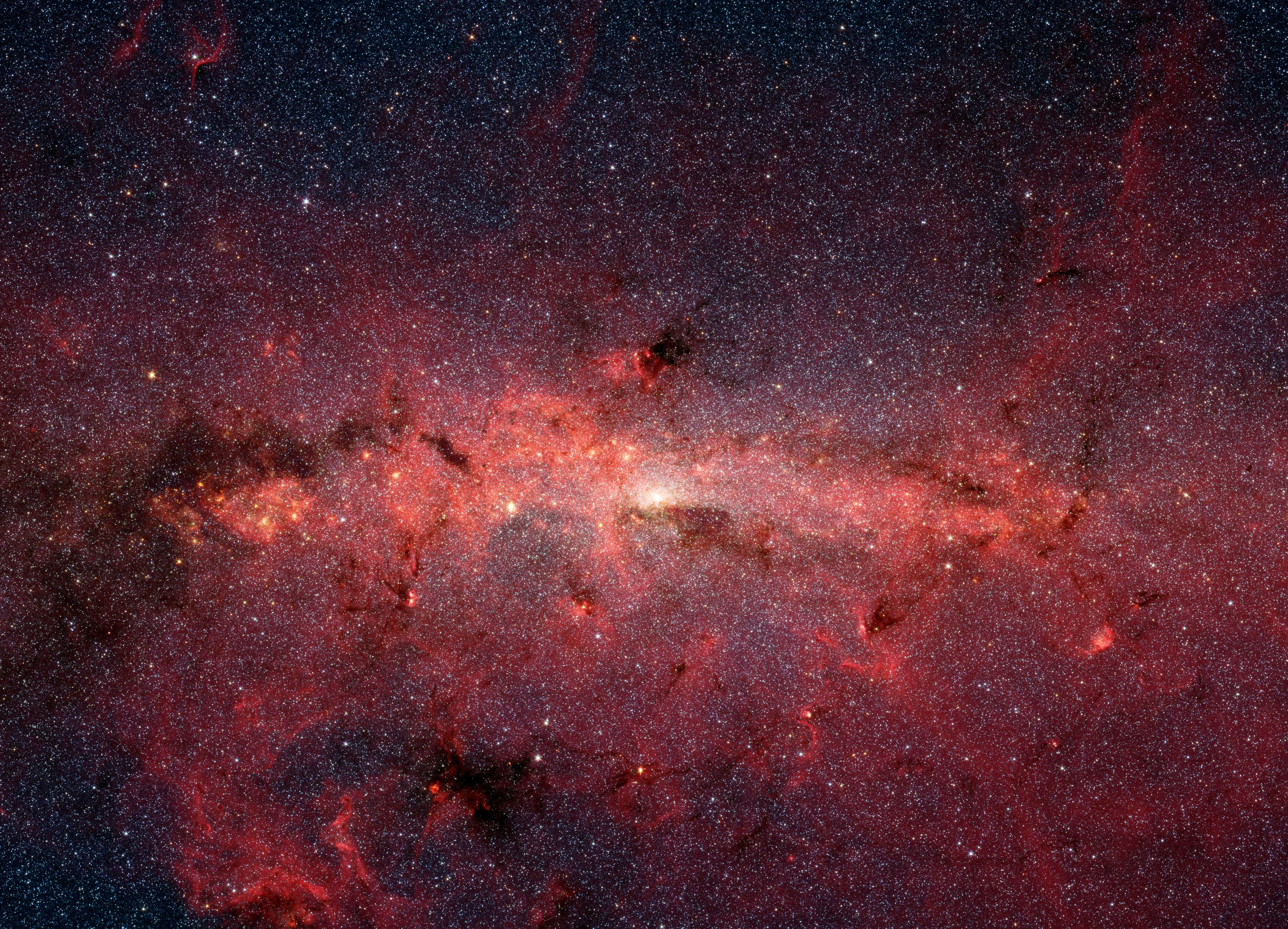 Mysterious phenomenon at the heart of the Milky Way could point to a new dark matter suspect A line of dense red dust and gas against a fainter red background