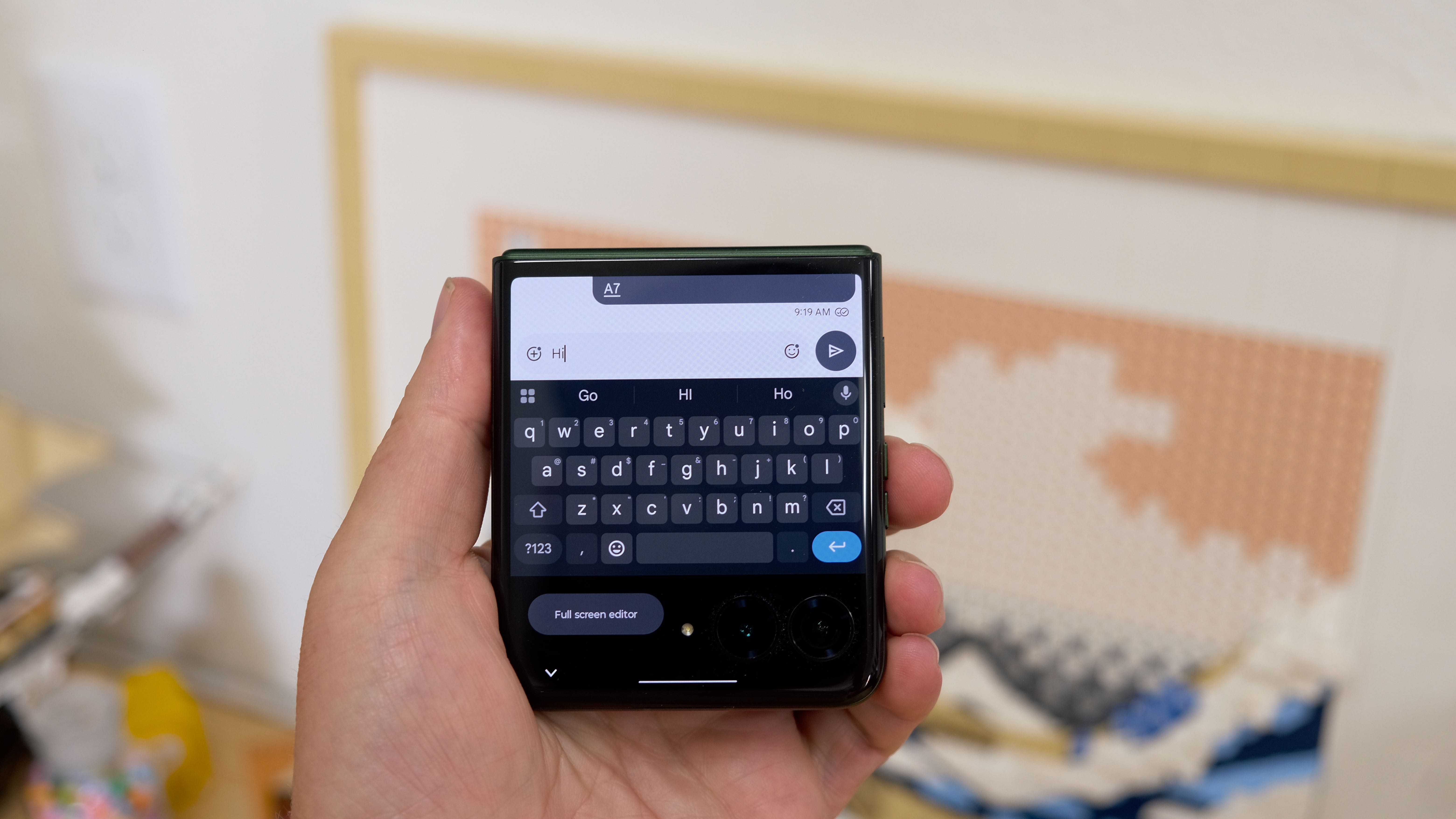 The Motorola Razr Plus 2026 in hand and on a wooden table