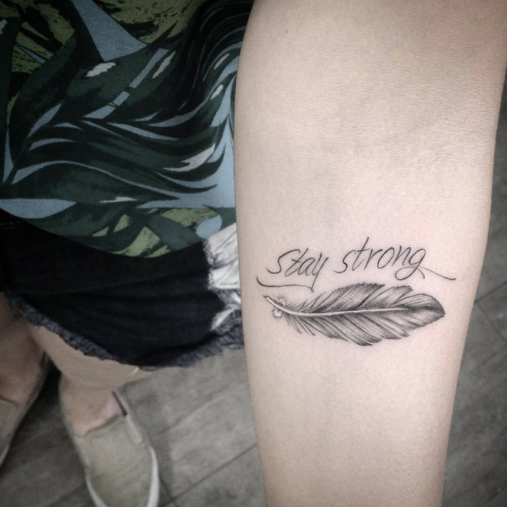 Forearm tattoo saying "stay strong", together with a