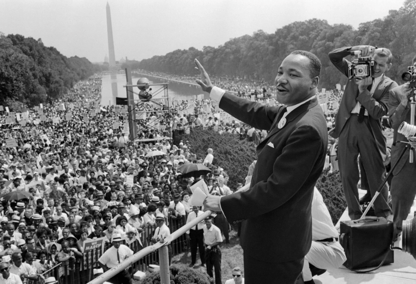 Man standing outside in front of a large gathering of people