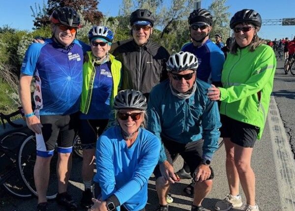 Group of cyclists posing together outdoors.