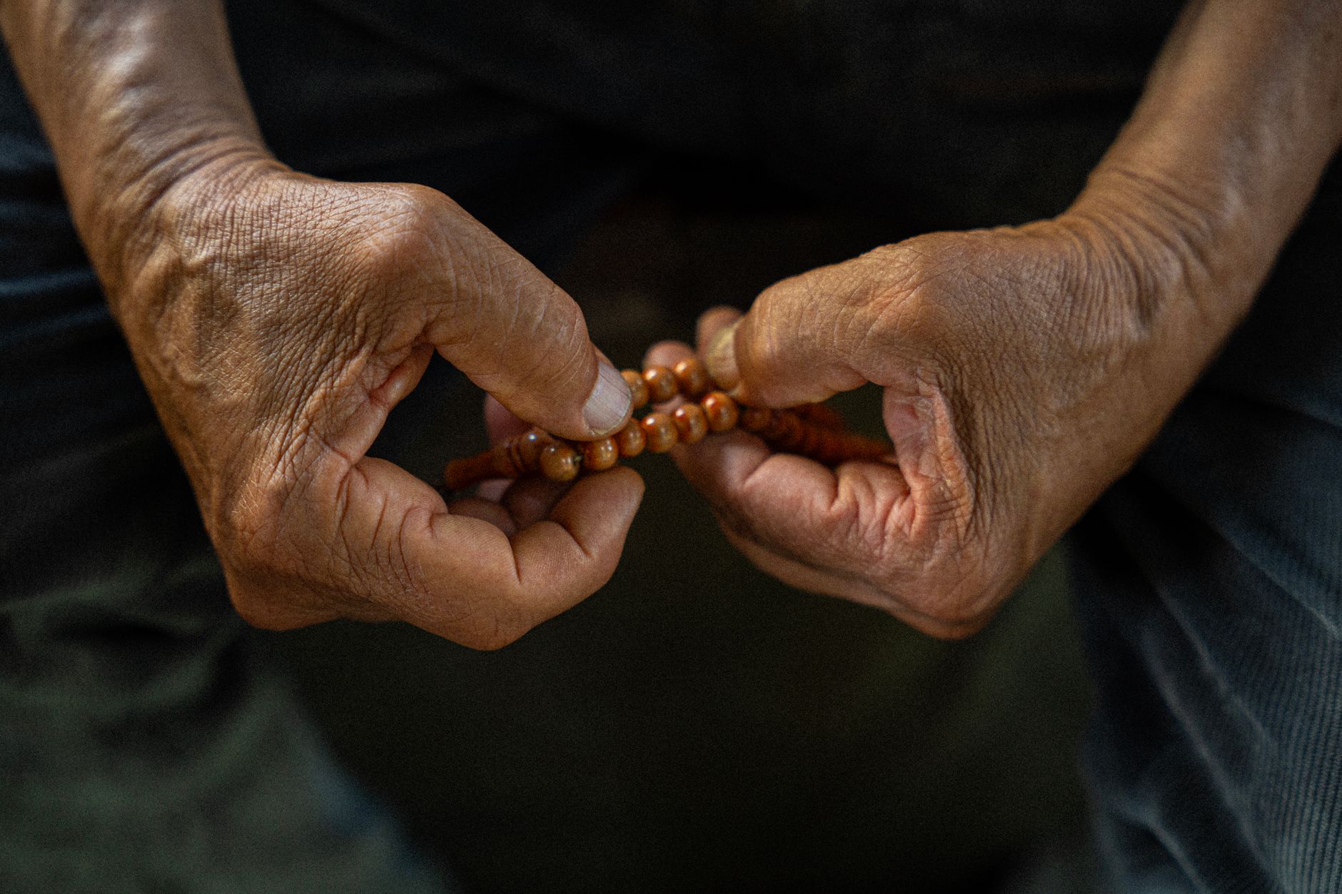 close up of hands holding prayer beads