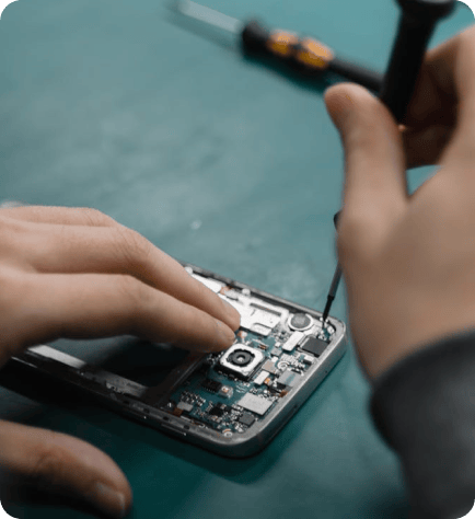 Technician using precision tools to repair an open Cell Phone screen on a clean workbench