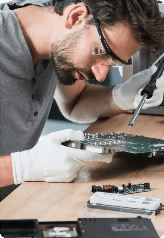 Technician using precision tools to repair an open Motherboard of a laptop on a clean workbench