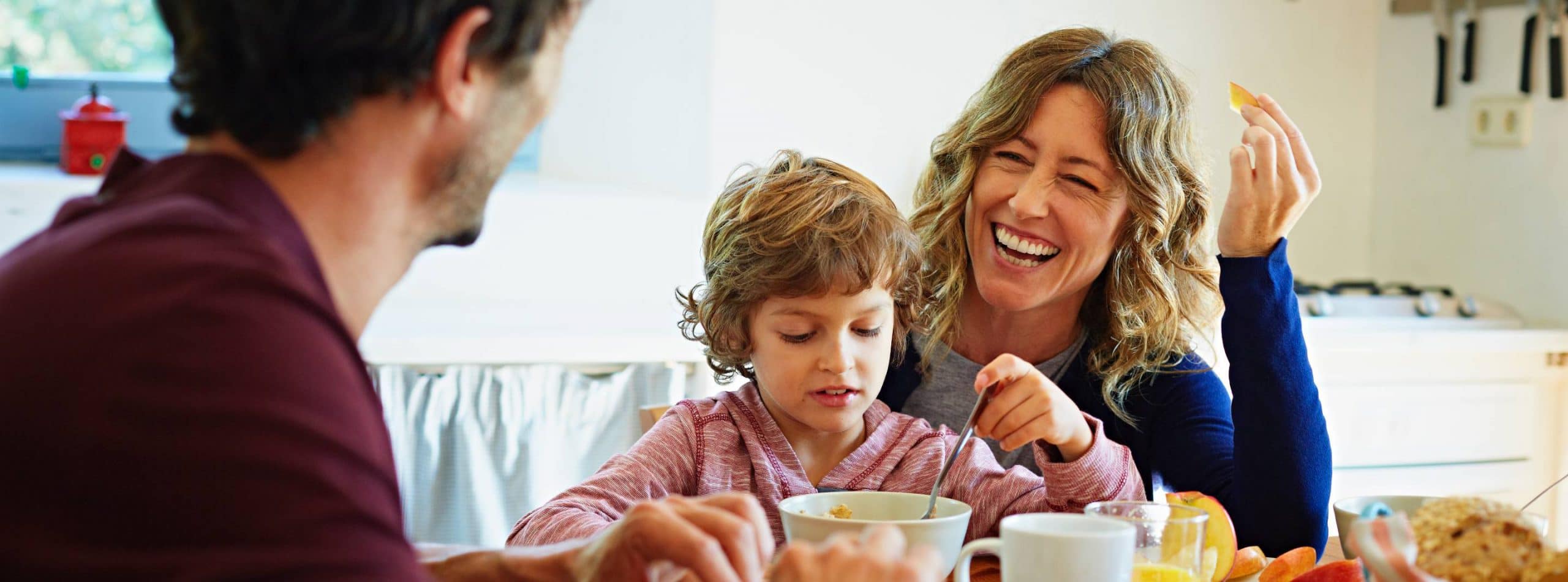 A family eating breakfast at the kitchen table
