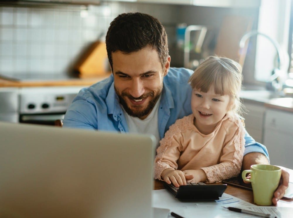 Father and daughter looking at laptop and balancing budget