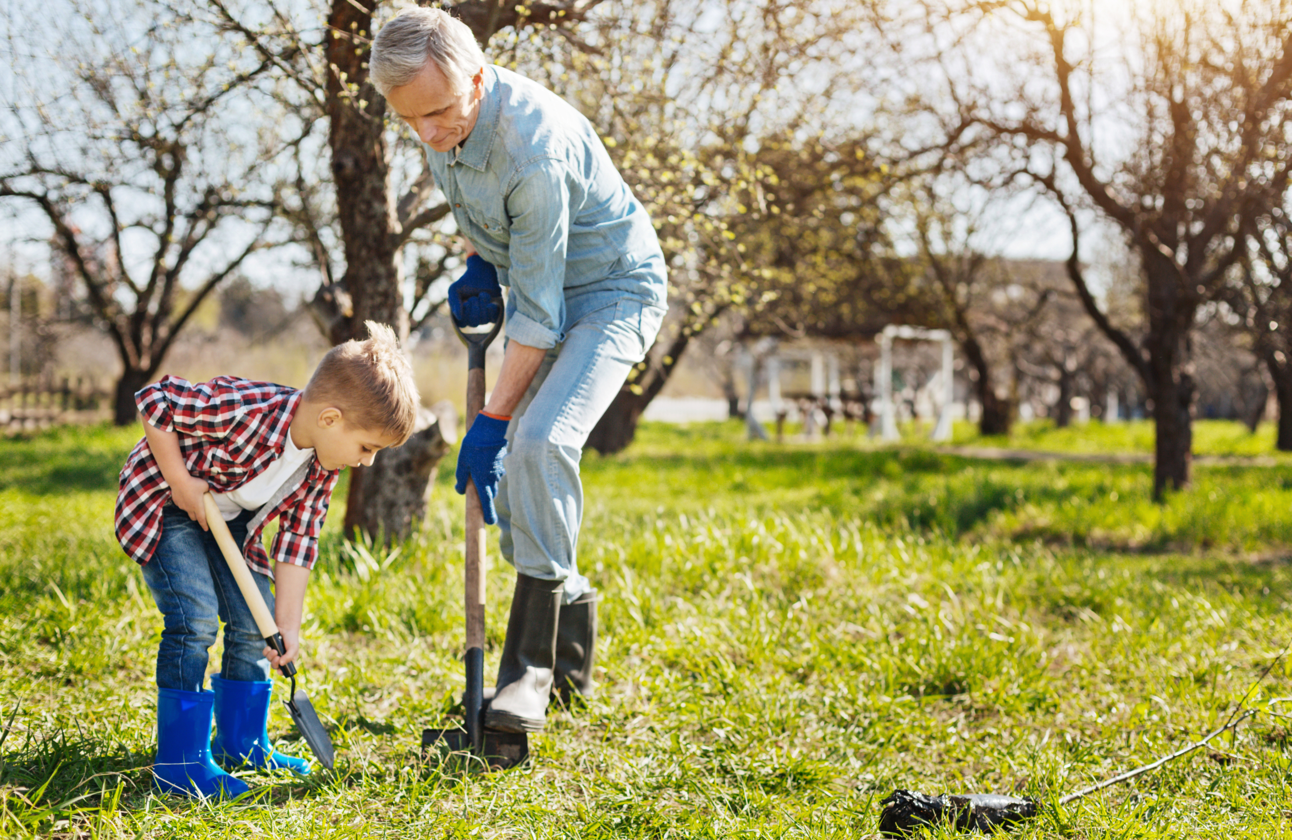 Adult and child digging in a grassy yard, a reminder to call 811 before digging near underground utility lines