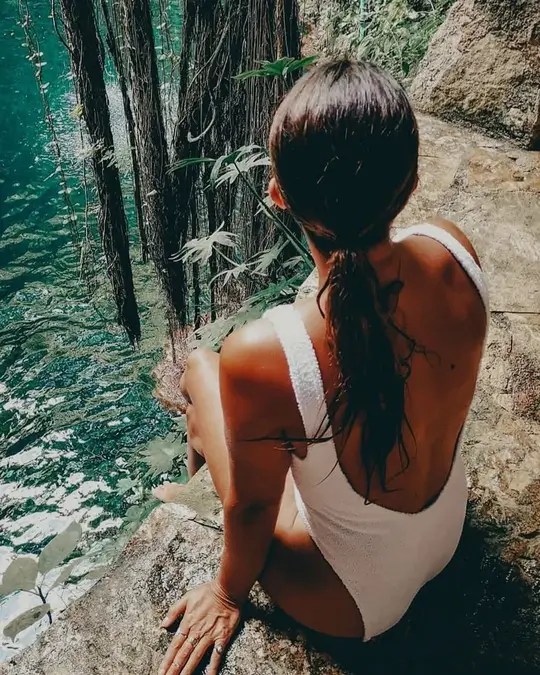 Woman sitting on the edge cenote IK KIL