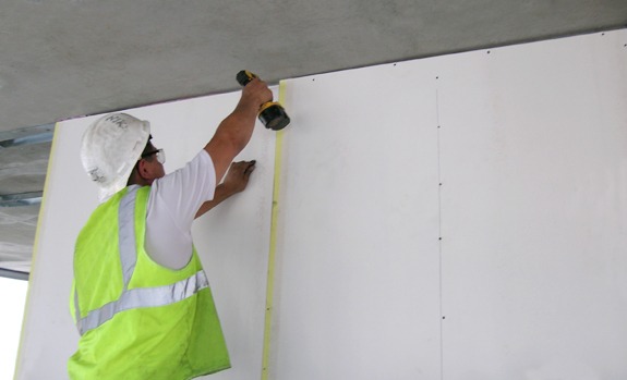Using a drywall lift, position the piece on . Drywall and Insulation Supplier | Century Building Materials