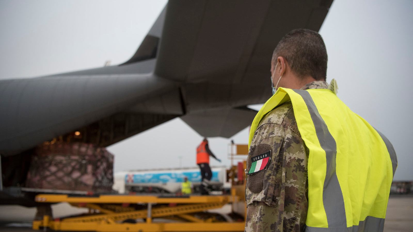 An Italian air force member stands-by as a pallet of medical supplies from Milan, Italy is off-loaded in Rome, May, 13, 2020. In response to the ongoing coronavirus disease 2019 outbreak, an 86th Airlift Wing C-130J Super Hercules assisted the Italian government in transporting medical supplies between supply hubs in Milan and Rome, Italy. (U.S. Air Force photo by Senior Airman Kristof J. Rixmann)