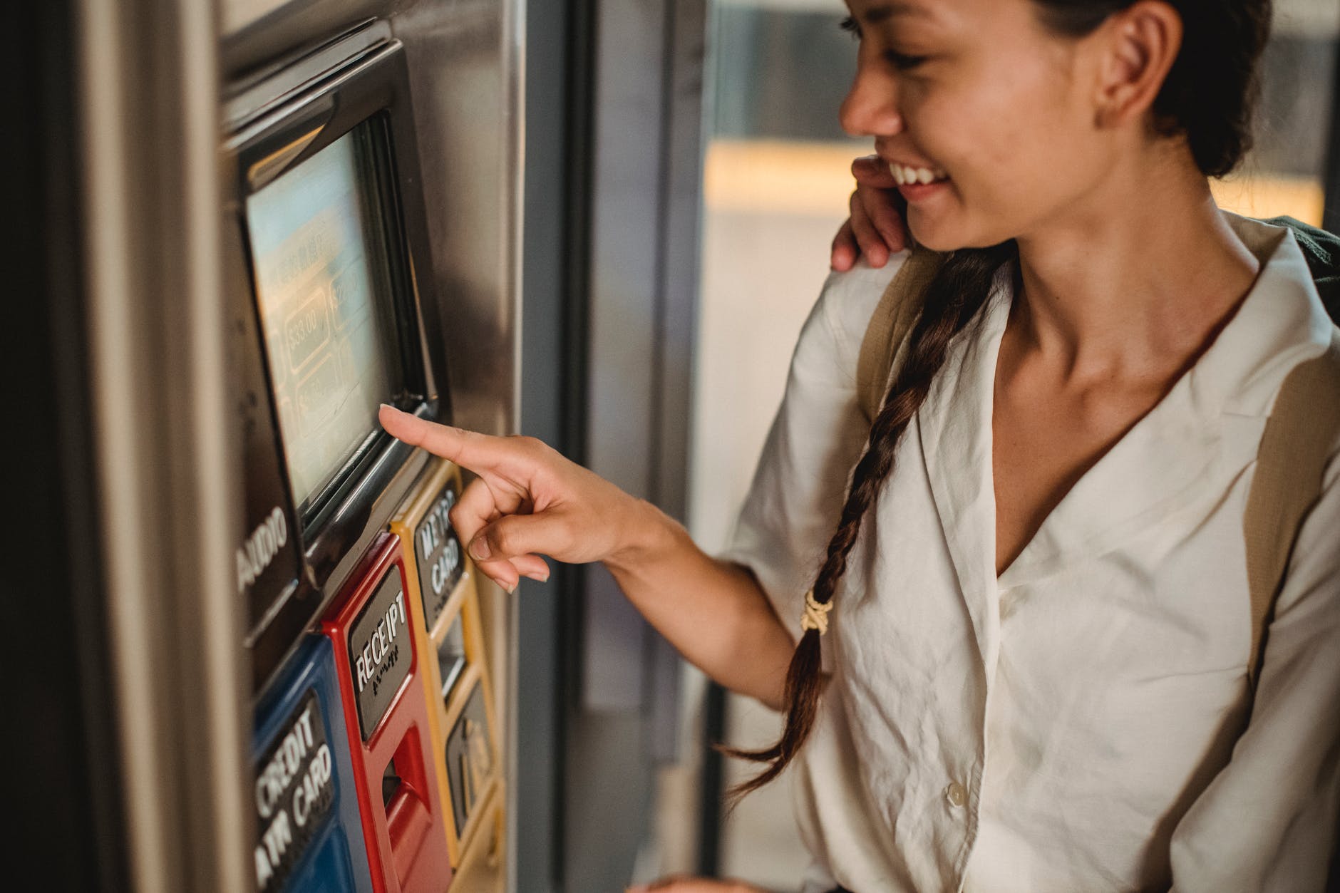crop cheerful asian woman using ticket machine