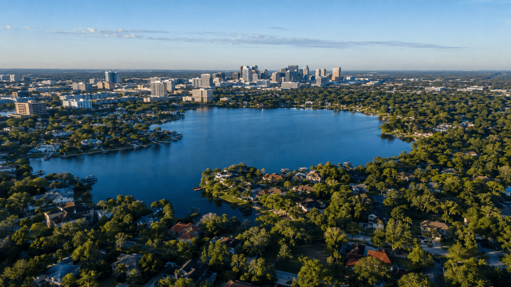 Aerial view of an Orlando lake, neighborhoods, and downtown skyline in Orange