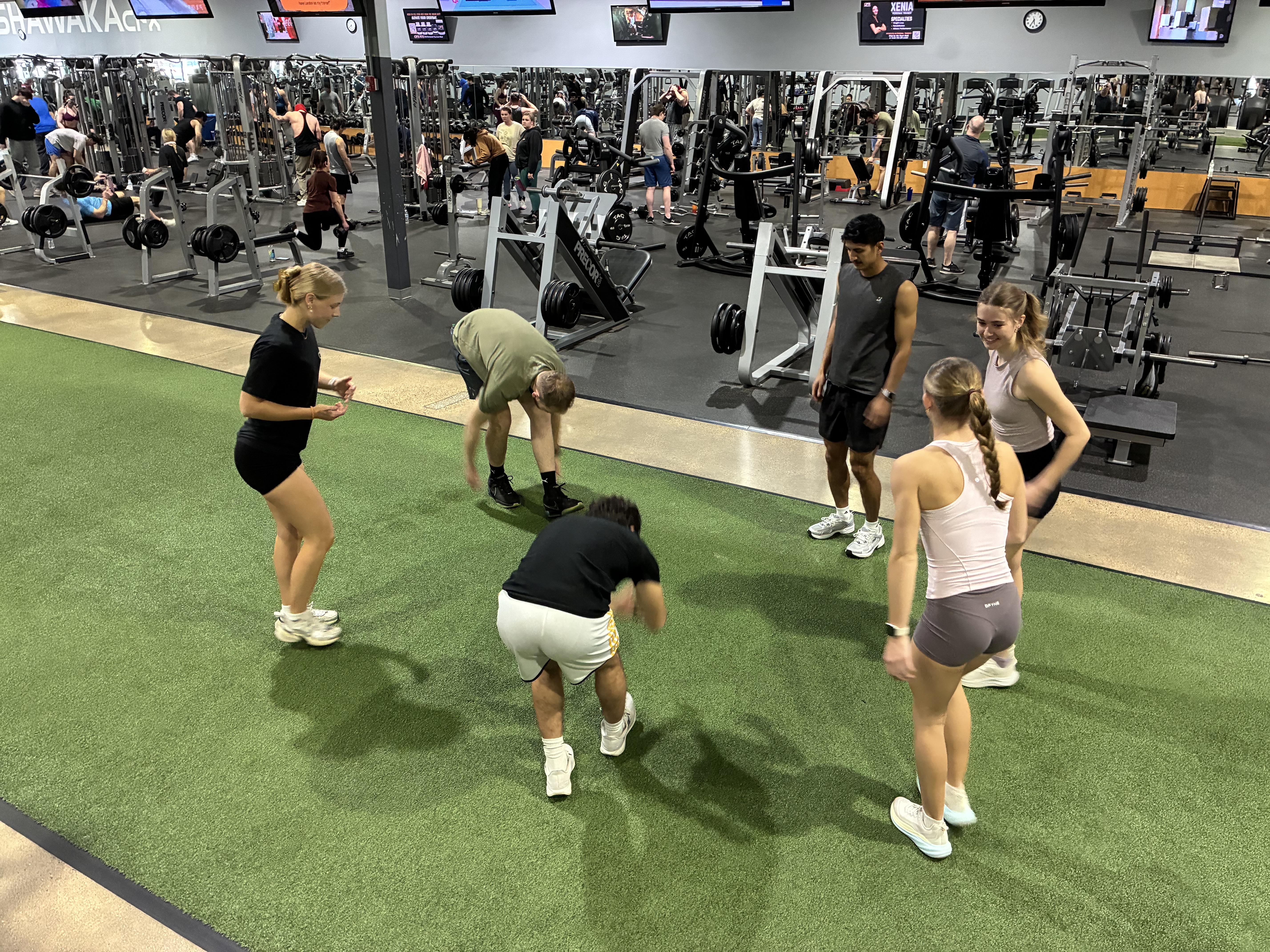 CFX group fitness class training together on the turf area inside a CFX gym