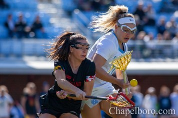 IMG_7943 Taylor McDaniels (10) battles with a Maryland defender for a loose ball as UNC women's lacrosse takes on Maryland at Dorrance Field in Chapel Hill on Saturday, February 22. (Dakota Moyer/Chapelboro.com)
